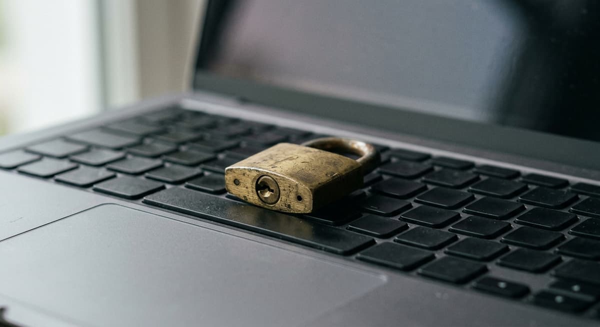 candado de bronce sobre el teclado de una laptop