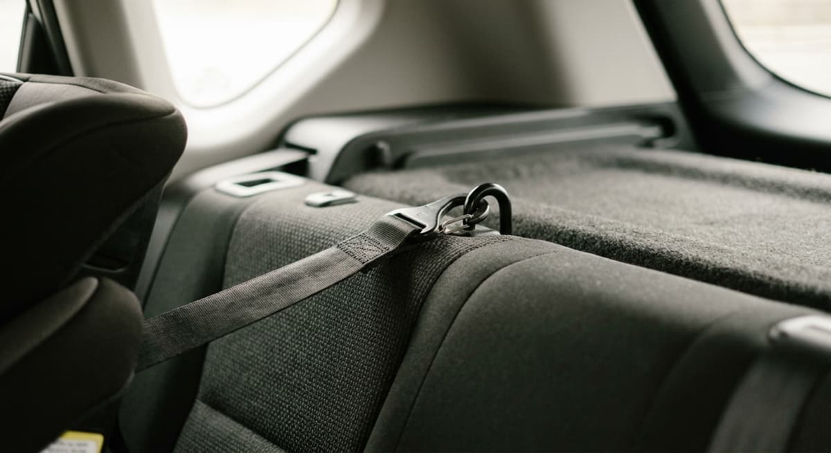 Una correa de anclaje superior enganchada a un punto de anclaje detrás del asiento trasero