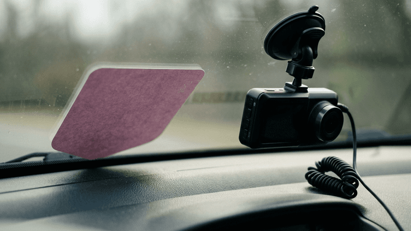 Texas uber or lyft trade dress placard visible on a car dashboard beside a dashcam