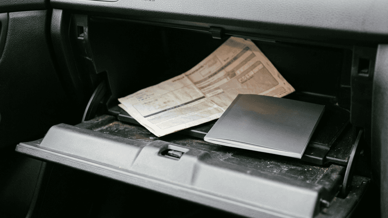 Virginia glove compartment open showing a vehicle registration and dashcam manual