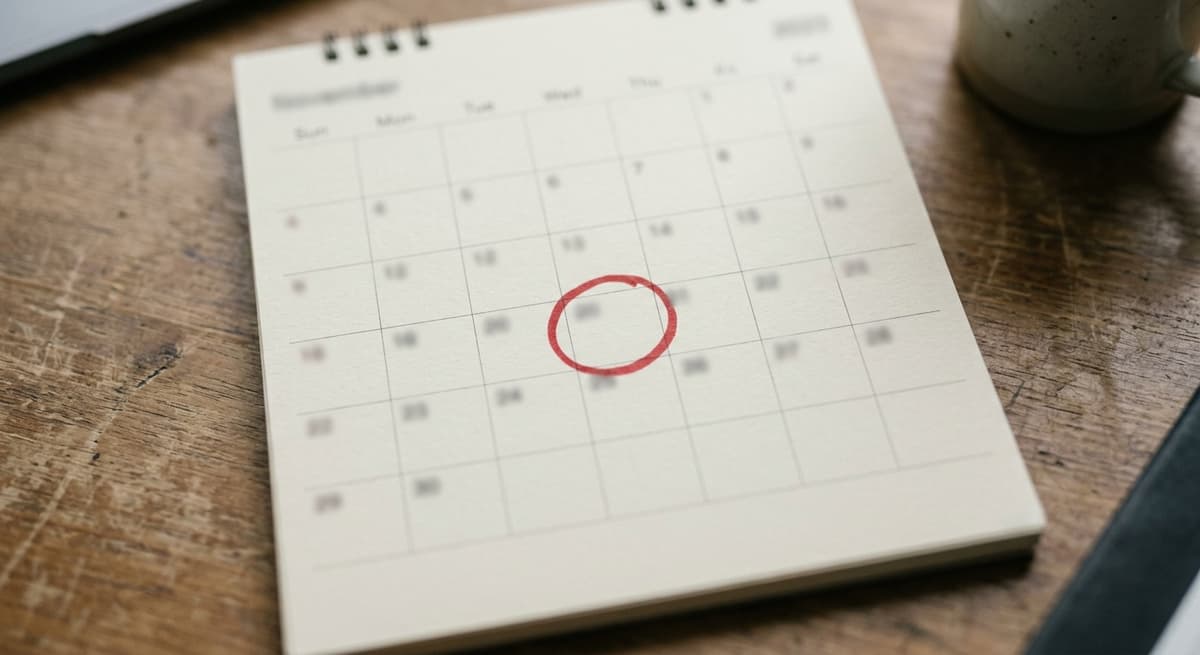 a desk calendar page with a red circle around one date, shallow depth of field, numbers unreadable