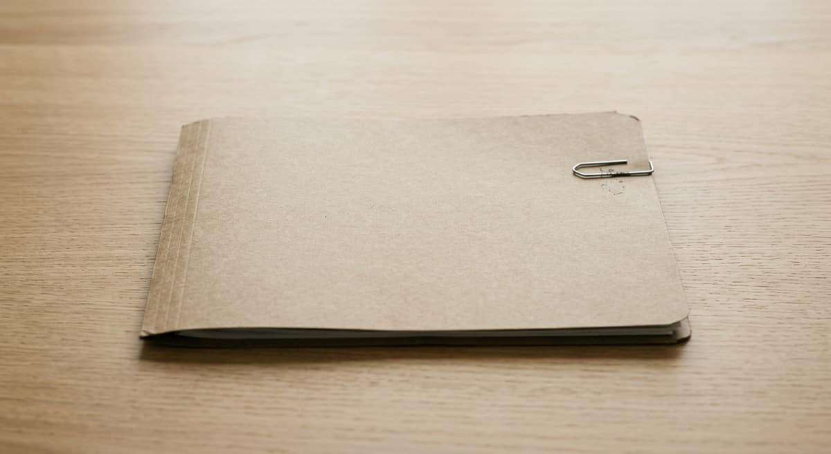 Oklahoma closed file folder with a single paper clip on a clean light wood desk