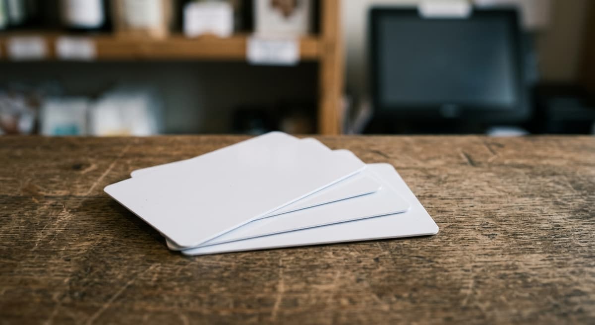 a small stack of gift cards fanned out on a counter, faces blank and unbranded