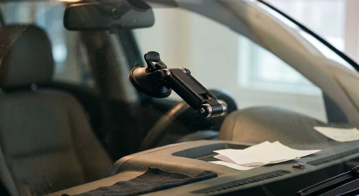 Un brazo articulado de soporte para parabrisas vacío, plegado contra el vidrio