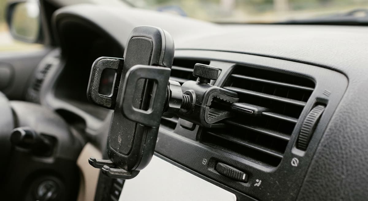 A vent-clip phone holder attached to dashboard air vents, empty